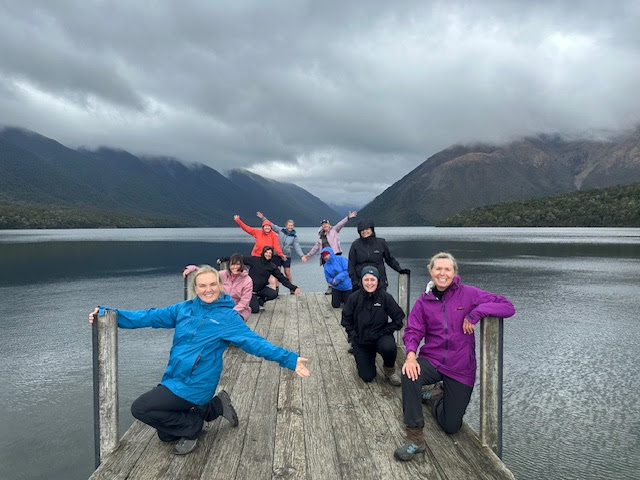 Georgie discovering friends in Adventure, on a pier on an overcast lake