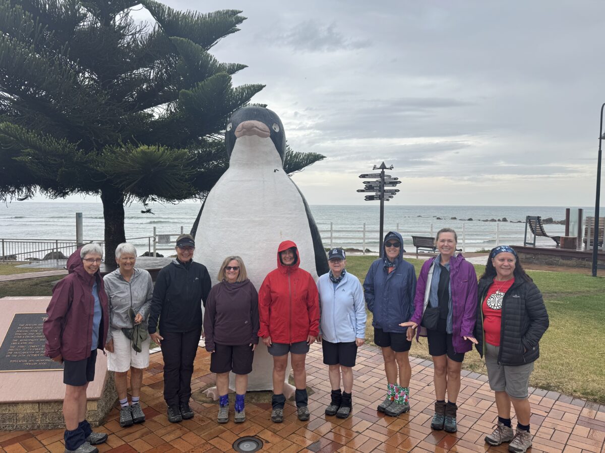 The Women's Fitness Adventures CREW in front of a Penguin statue in Penguin on the road to the Tarkine