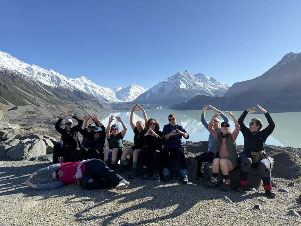 Group of women hikers posing by alpine lake